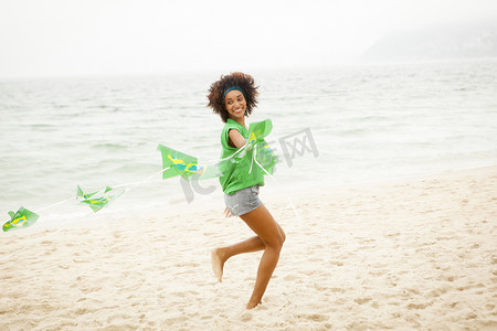 巴西里约热内卢一名年轻女子在海滩上玩旗子