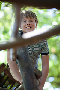 男孩在户外攀登丛林攀登架