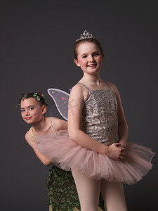 芭蕾舞皇冠摄影照片_穿粉色短裙的女孩和穿绿色连衣裙的女孩