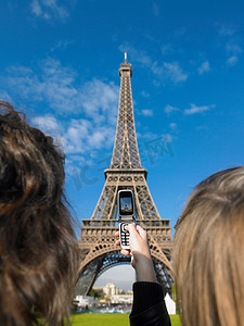 拍照旅游景点摄影照片_为埃菲尔铁塔拍照的妇女