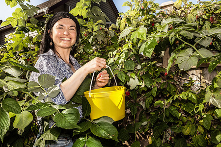 微笑的女人在花园里摘水果