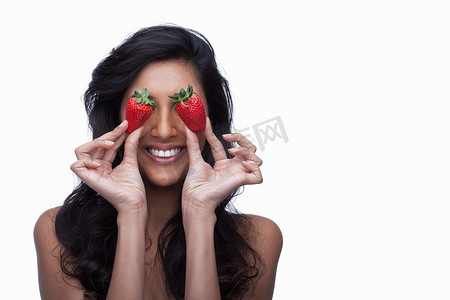 年轻女子用草莓遮住眼睛