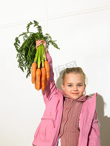 阿利茄汁面摄影照片_拿着一串胡萝卜的女孩