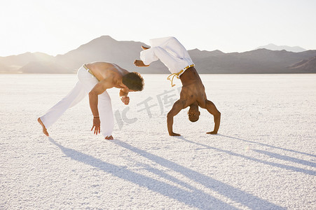 两名男子在美国犹他州的波纳维尔盐滩表演卡波埃拉