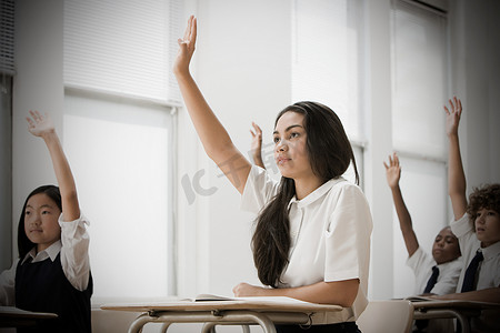 东南亚人摄影照片_举手的学校学生