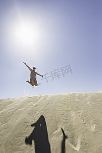 年轻女子在半空中跳跃法国皮拉特沙丘