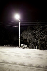路上雪摄影照片_夜间雪路上的路灯