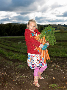 垂直农业摄影照片_拿着一串胡萝卜的女孩
