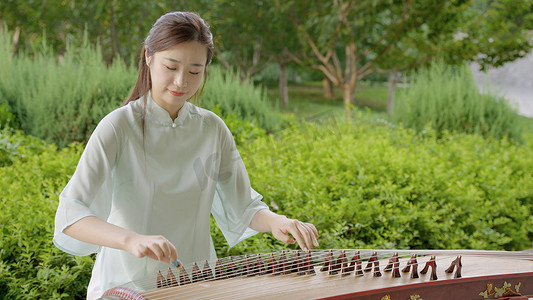 树林公园旗袍少女弹奏古筝乐器