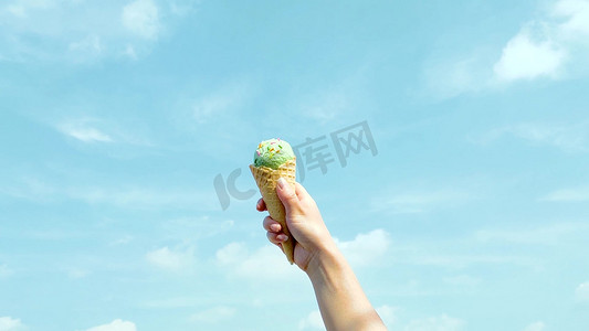 天空摄影照片_夏天实拍蓝天下女孩举起手中的冰激淋