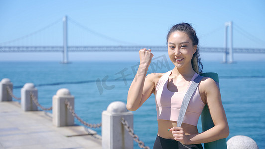 朝气摄影照片_美女被瑜伽垫晨练加油手势积极向上状态人物