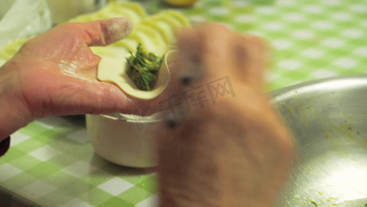 年味包饺子摄影照片_实拍新年氛围年味老人手工包饺子手部特写