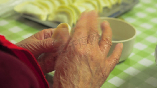老人摄影照片_实拍新年氛围年味老人手工包饺子手部特写