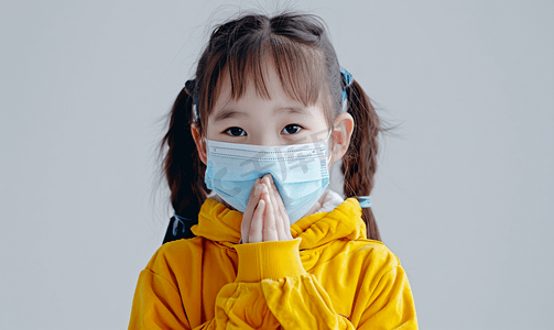 幼儿咳嗽摄影照片_小女孩戴着口罩咳嗽