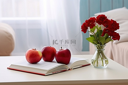 白色附近桌子上的书籍和红苹果