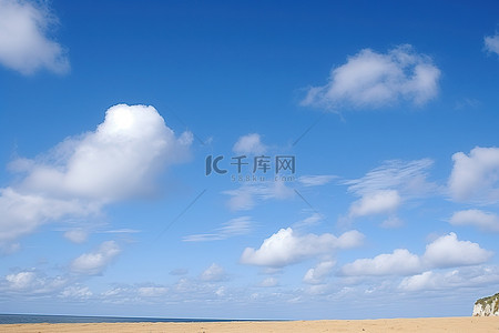 悬崖上的人背景图片_蓝天白云和沙漠海滩上的悬崖
