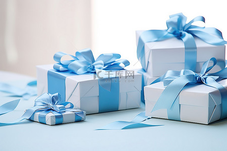 丝带白色背景图片_桌子上的蓝色和白色礼品盒