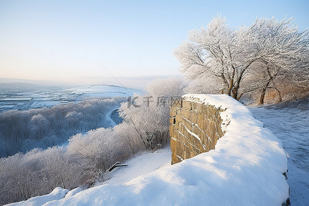 一块被白雪覆盖的冰冻石头俯瞰着冬日的雪景
