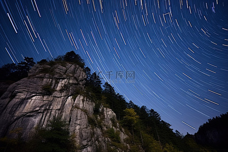 星迹在岩石表面上留下痕迹，上面有一些高大的树木