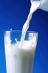 一杯牛奶倒在蓝色背景上