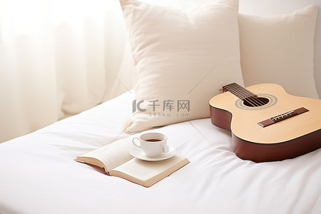 吉他，早餐杯咖啡，枕头上的书，铺在白地毯上