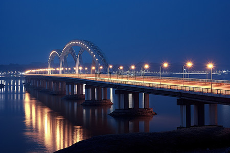 水桥城市背景图片_夜间水面上的一座长桥