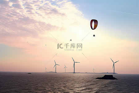 滑翔伞在风力涡轮机的海洋上空飞行