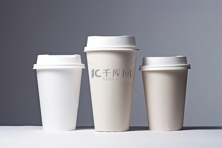 图像中的三个咖啡杯和一个盖子
