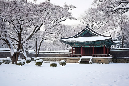 一座石头建筑，树木和长凳被雪覆盖