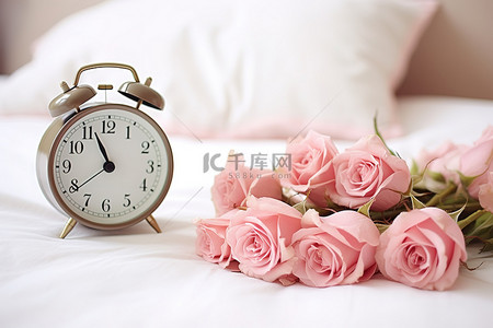 床上的粉红玫瑰，床边的时钟旁边