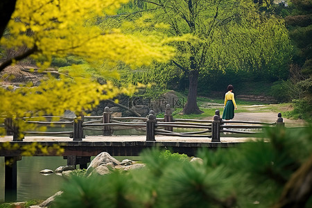 行走的女人背景图片_那个女人正在一座俯瞰湖泊的桥附近行走