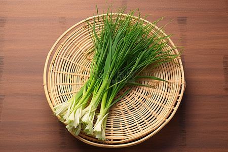 食品放桌上背景图片_桌上放着杂草和葱的篮子