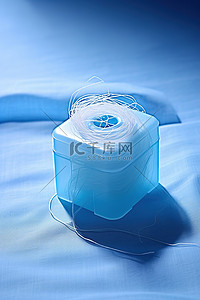 潦草线团背景图片_一个电动纸巾盒旁边放着一团白色的线