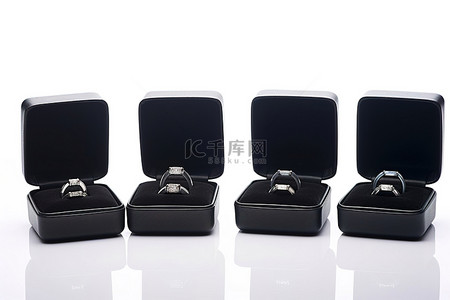 四个黑色盒子，里面装有几枚钻戒