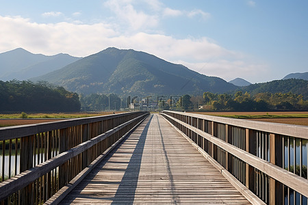 一座木桥通向空旷山谷中的山脉