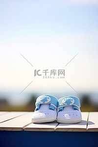 毛主度的袜子背景图片_白色木凳上绣有蓝色袜子的蓝白色婴儿鞋