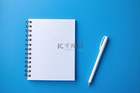 蓝色背景上的笔记本和铅笔