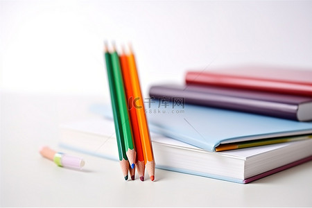 白色表面上的彩色铅笔和笔记本