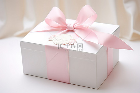 盒子粉色背景图片_一个白色盒子，上面有一条粉红色丝带和一个标签