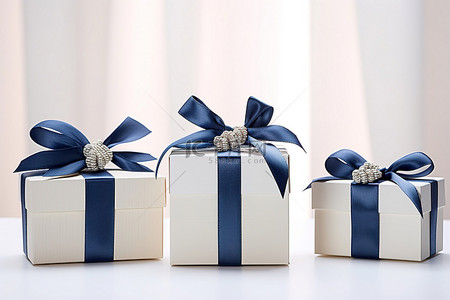儿童英语海背景图片_三个带蓝丝带和白色蝴蝶结的礼品盒