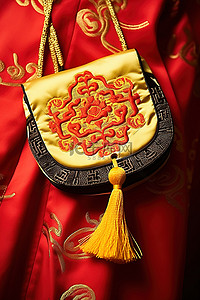 传统服装背景图片_一件中国传统服装，上面挂着一个红黄黑的钱包