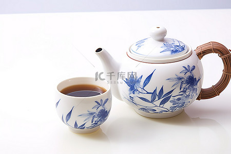 棕褐色的中国茶壶，旁边放着一杯红茶，旁边是植物 yan 123