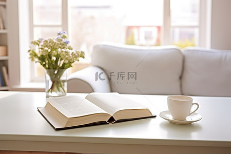 一张白色的桌子，上面有打开的书咖啡和咖啡杯