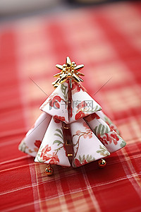 格子背景布背景图片_一块折叠的圣诞织物树，放在红白格子布上