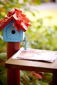 信封小背景图片_邮件放在红色小鸟舍旁边的桌子上