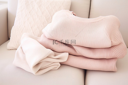 沙发上的三件淡粉色毛衣