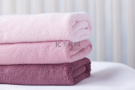 粉色淡背景图片_四块柔软的棉质毛巾粉色淡紫色和粉色叠起来