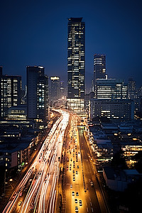 高楼夜景背景图片_一座高楼林立夜间交通拥堵的城市