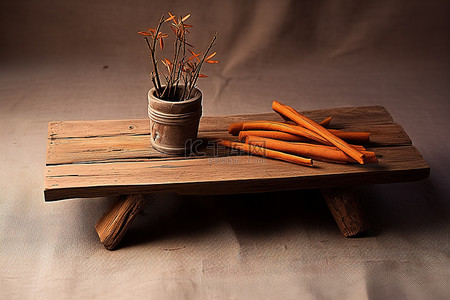 一张旧木桌，上面有橙色的棍子