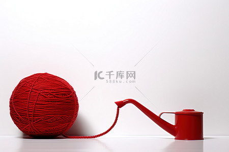 红球包裹着纱线，而喷壶在白色区域浇水